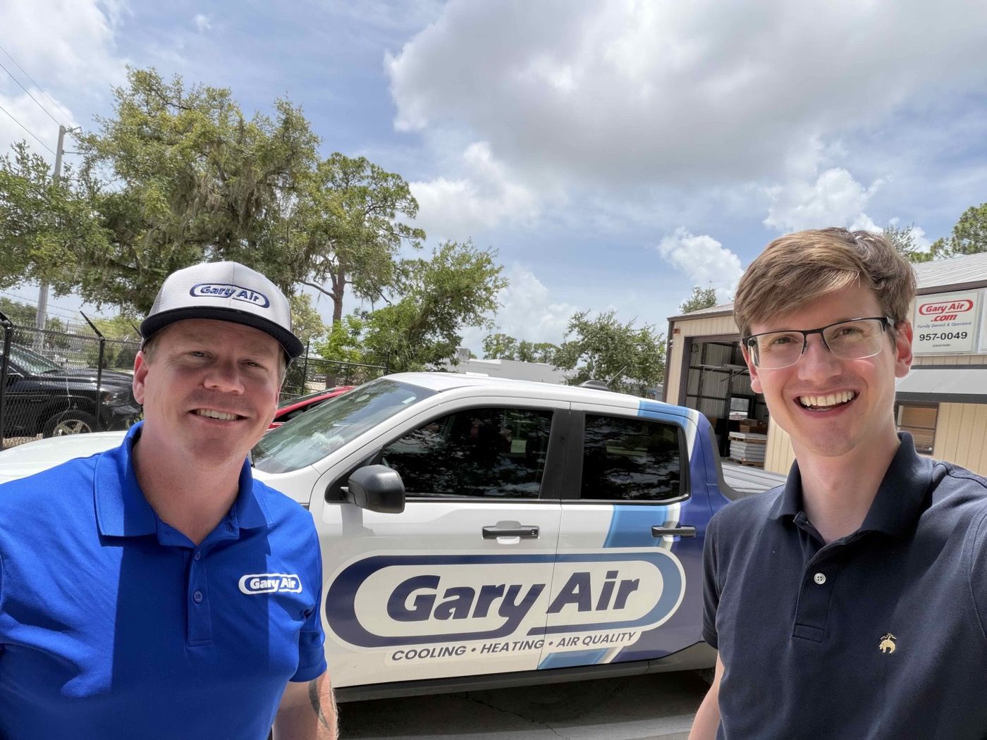 Rob Brooks and Grant Hensel smiling in front of a Gary Air branded truck outside the Sarasota shop